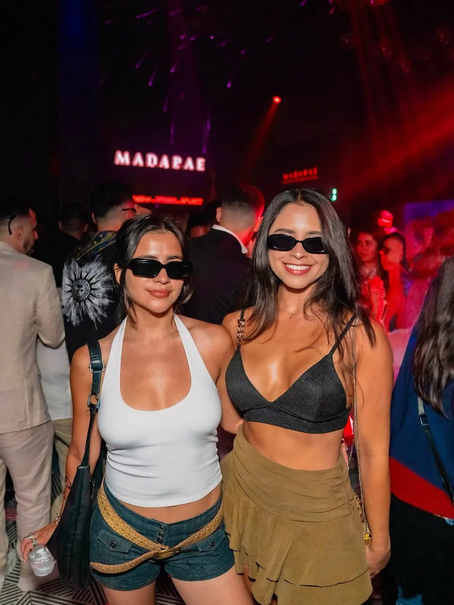 Two guests in sunglasses posing on the dance floor